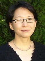 headshot of Nan Kim with dark green background