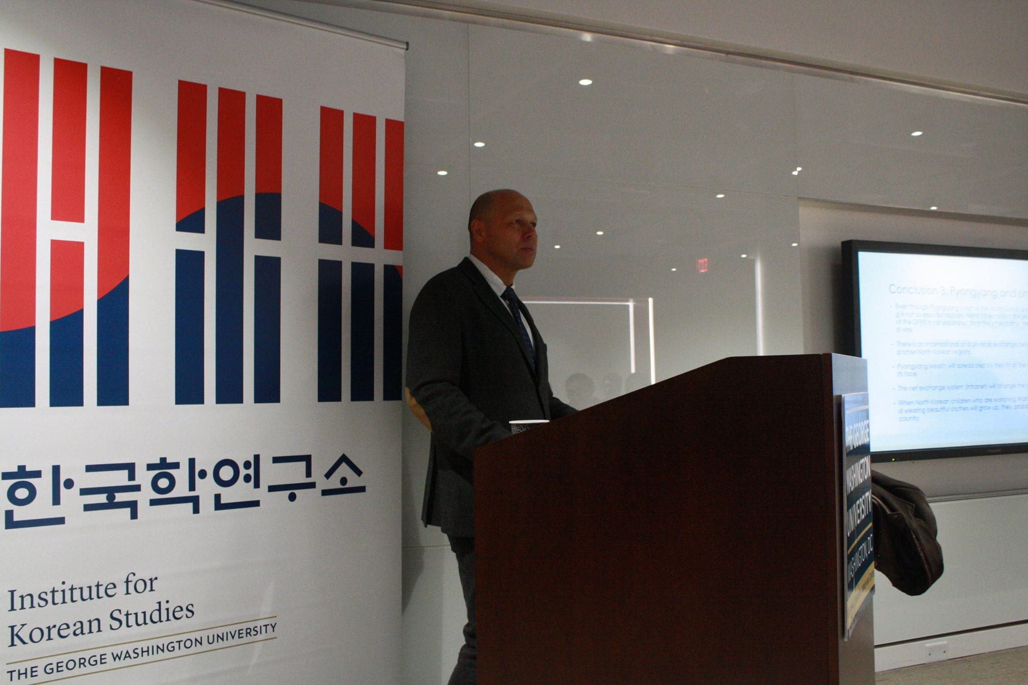 Sergei Kurbanov standing at podium giving presentation
