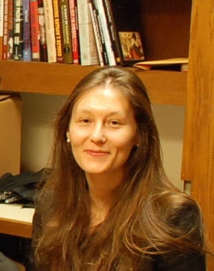 headshot of Justine Guichard with bookshelf in the background