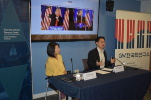 Jisoo Kim and Seong-hyun Lee sit at speaker table while Seong-hyun Lee addresses the audience