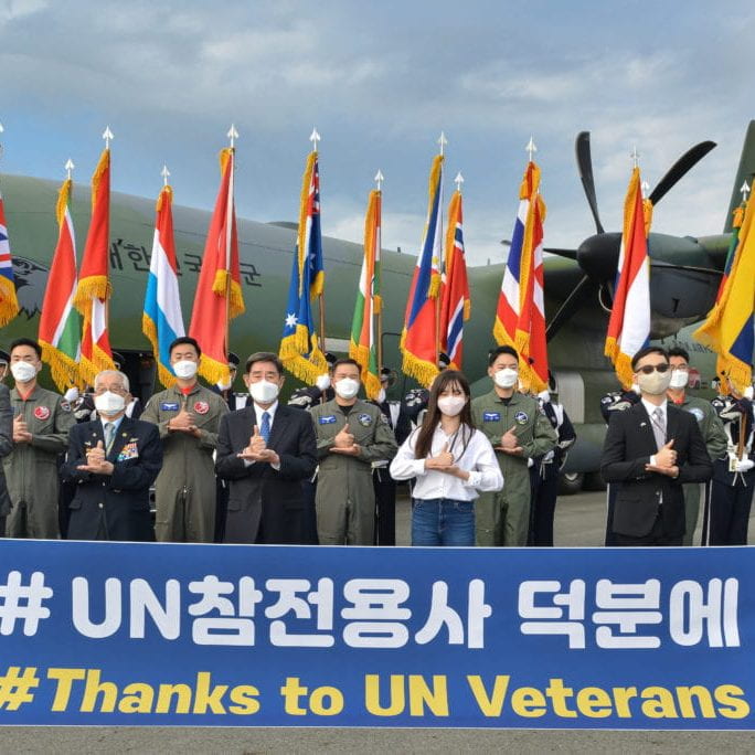 Korean military officers hold up sign to thank UN veterans for the Korean War