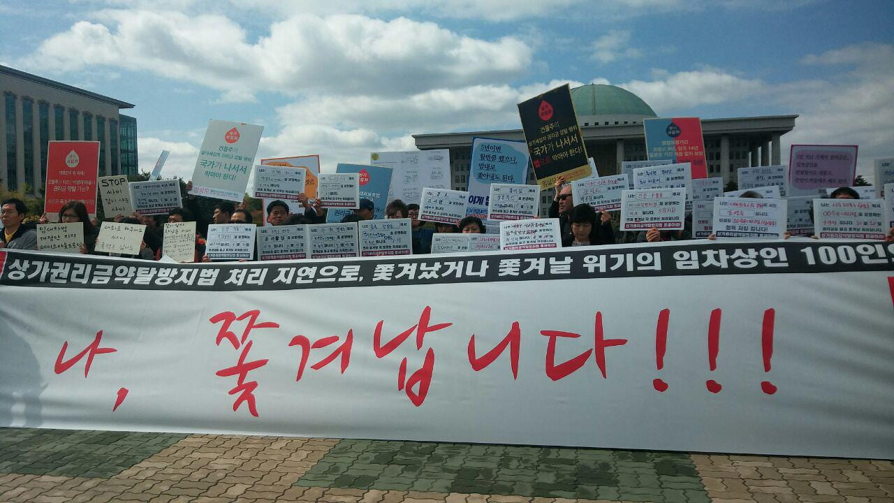 Koreans protesting for tenant rights and fighting eviction while holding up signs and banners in Korean