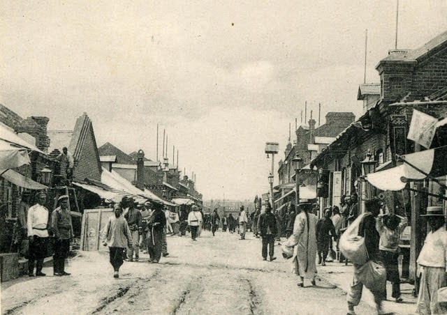 historical photo of a street with people coming and going